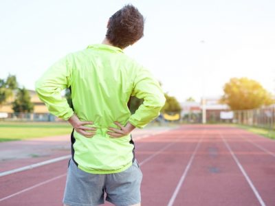 Runner on track grabs lower back in pain