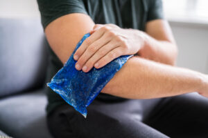 Man Using Ice Gel Pack On Injured Arm
