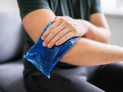 Man Using Ice Gel Pack On Injured Arm