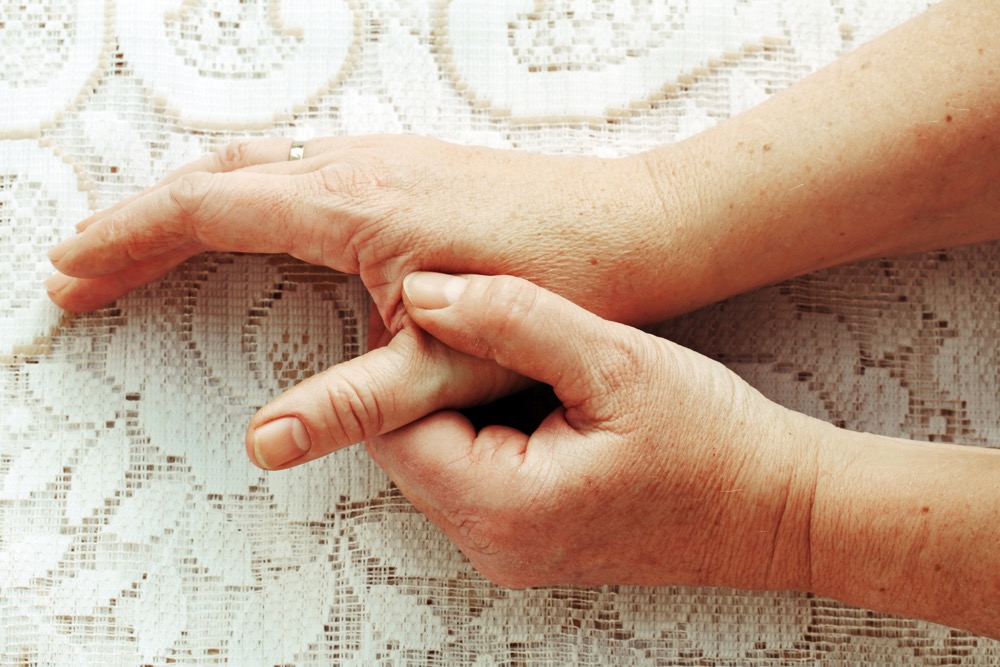 woman has pain in the fingers, hands, and joints
