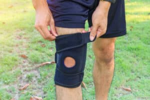 Man outside putting on knee brace