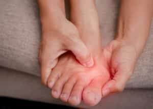 Person holding foot in pain due to sore bunions