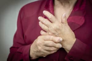 Woman holding her hands that are swollen with arthritis
