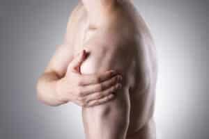Man holding his shoulder after a sports injury.
